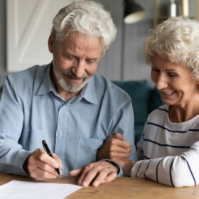 Elderly couple signing paperwork for their inheritance tax planning