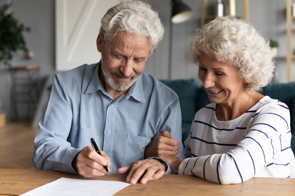 Elderly couple signing paperwork for their inheritance tax planning
