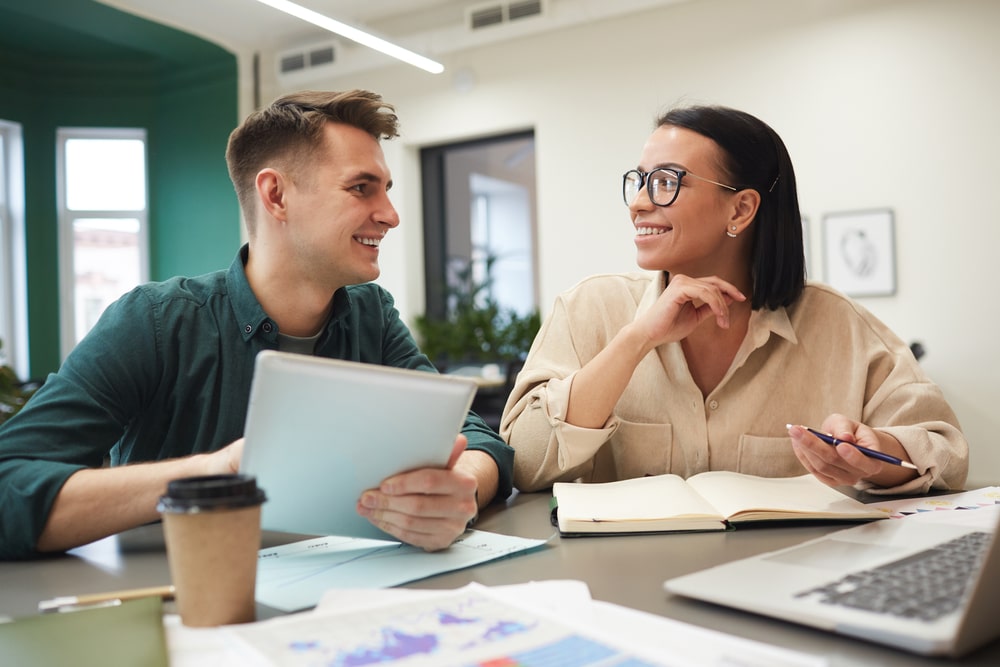 Two students discussing the benefits of tax free university fees at a desk